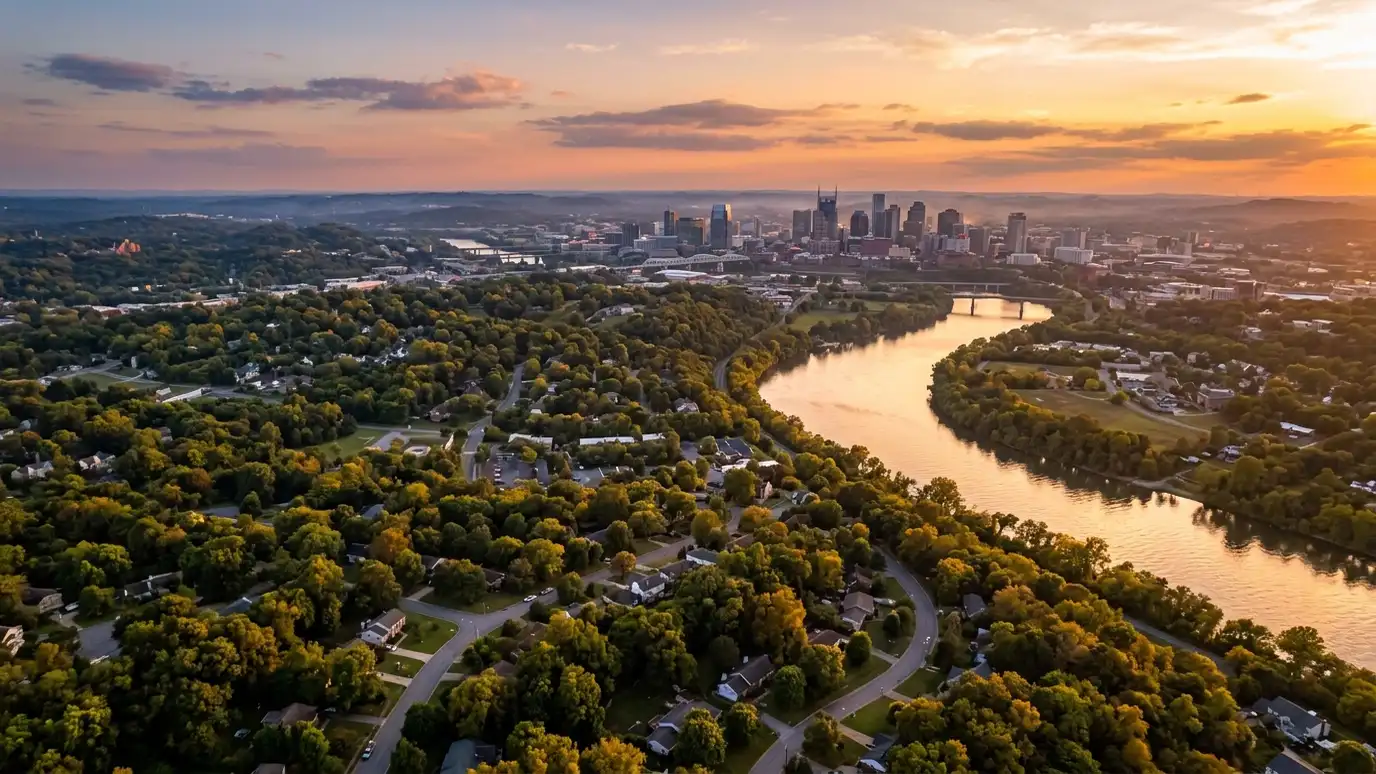 Architect service areas | Nashville and Middle Tennessee A golden sunset aerial view of the Nashville skyline above tree-covered suburban neighborhoods with a winding river